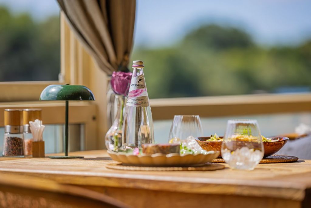 San Benedetto voda roze etikete na restoranskom stolu uz servirana jela za dvoje