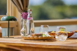 San Benedetto voda roze etikete na restoranskom stolu uz servirana jela za dvoje